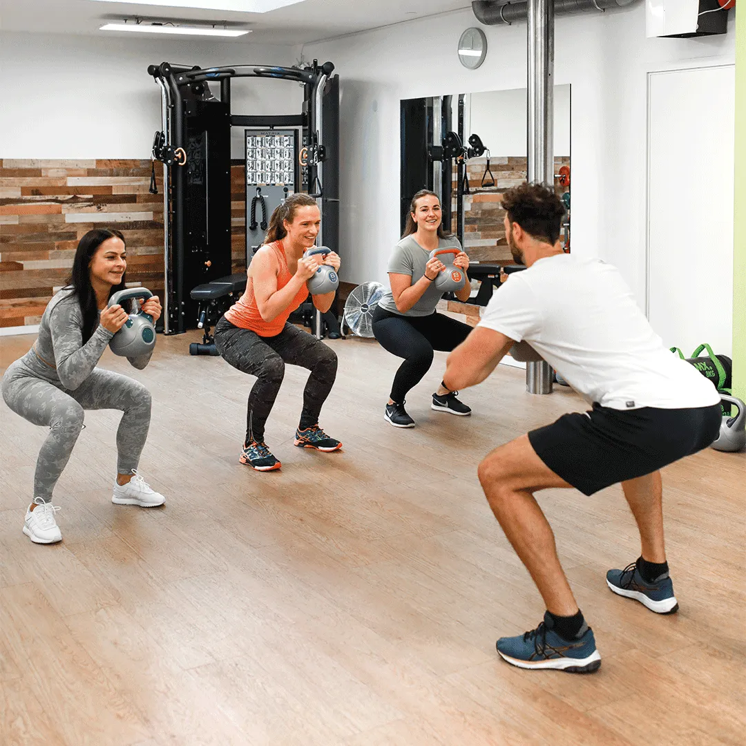 Fitness trainer teaching squat exercise